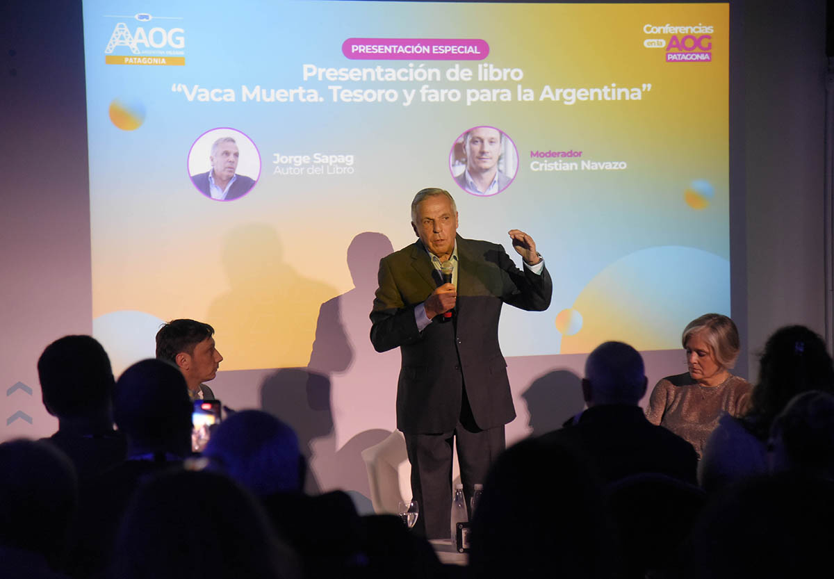 El exgobernador Jorge Sapag sostiene una muestra de roca de Vaca Muerta frente al auditorio de la AOG Patagonia.